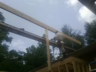 Carpenter setting a ridge beam over a new addition frame — Ice Dam Removal by Roofing Brothers in Green Mountain
