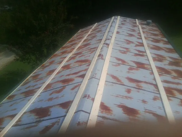 Rusted metal roof panels with new wood purlins before replacement — Storm Damage Roof Repair in Green Mountain by Roofing Brothers