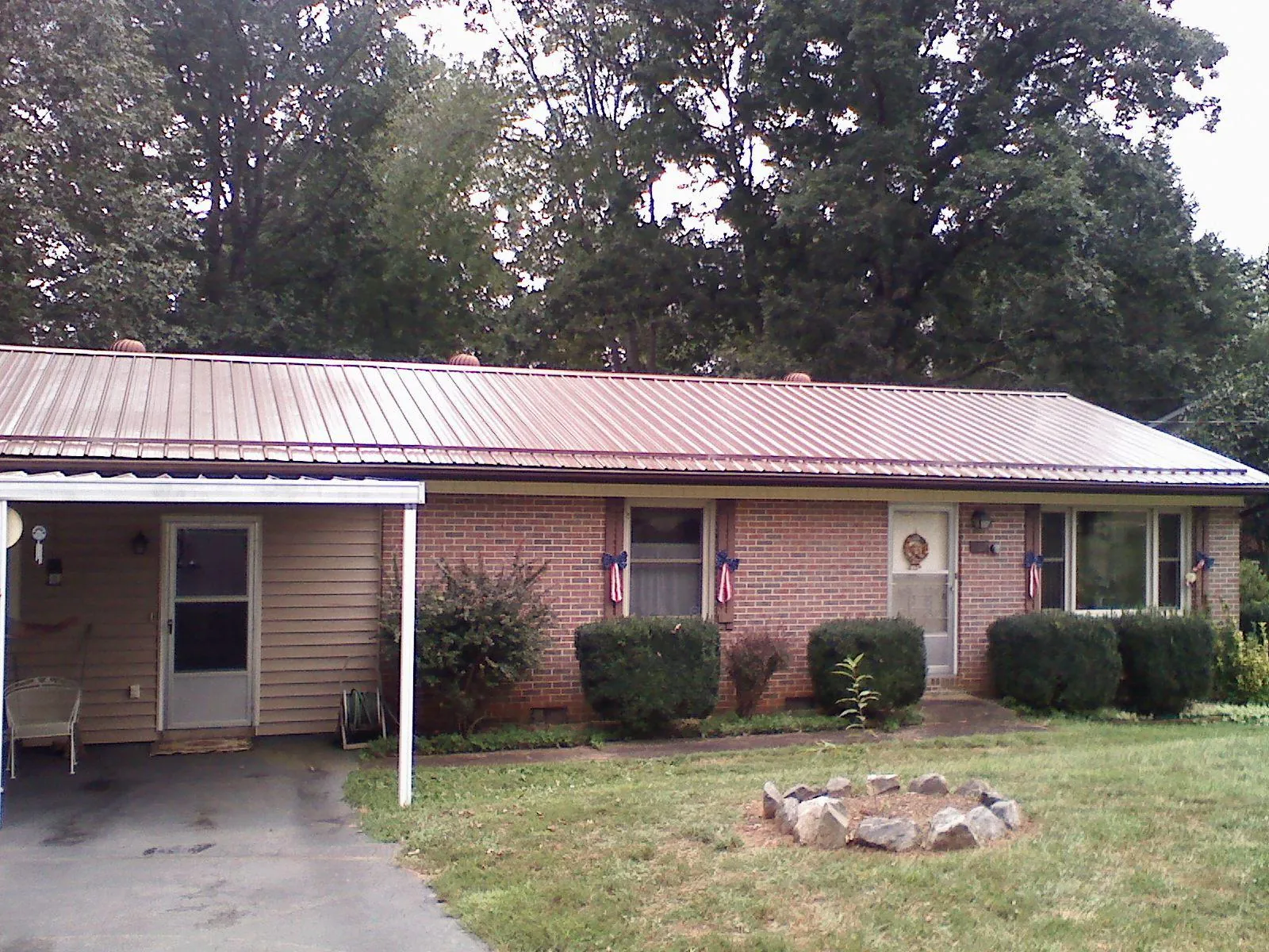 Bronze metal roof and carport on a brick ranch home — Roof Repair work by our crew in Green Mountain