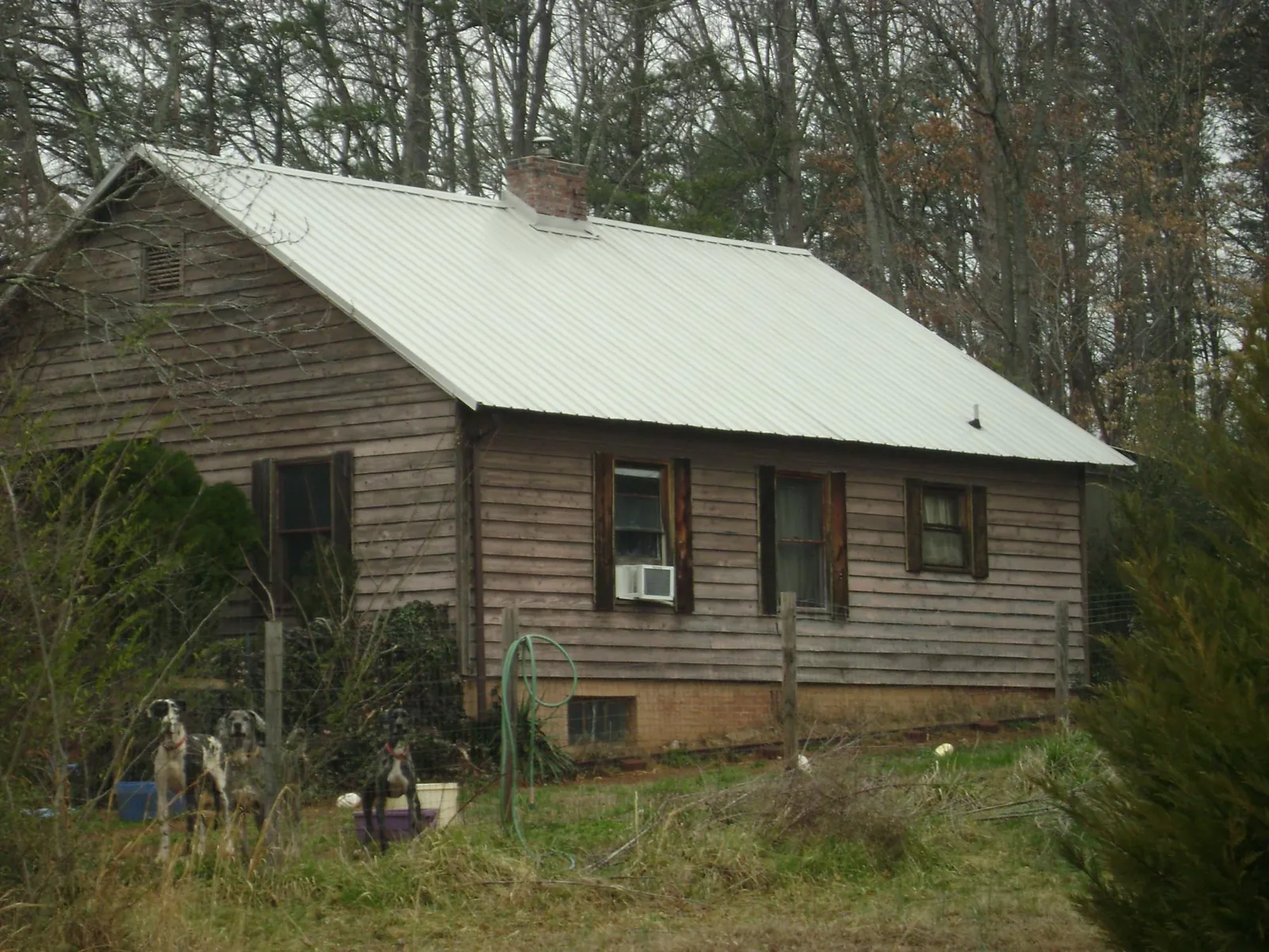 White metal roof on an old wood sided farmhouse, from a Metal Roof Installation job in Green Mountain